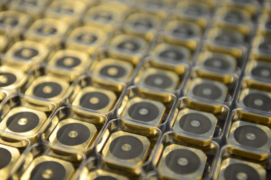 Viele viereckige Metallverbundteile mit Gummi in Versandpackungen