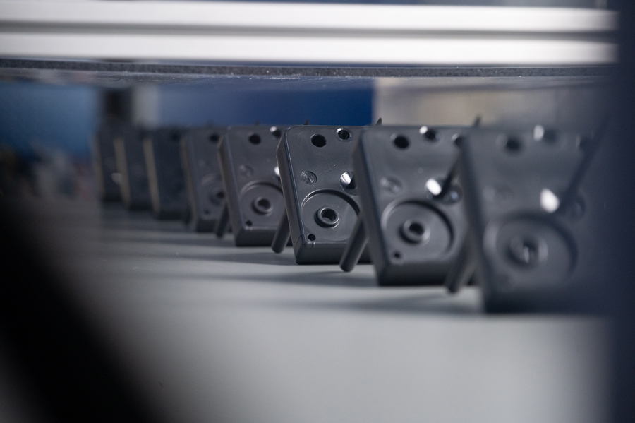 Viele schwarze, viereckige Kunststoffteile ordentlich in einer Reihe aufgestellt